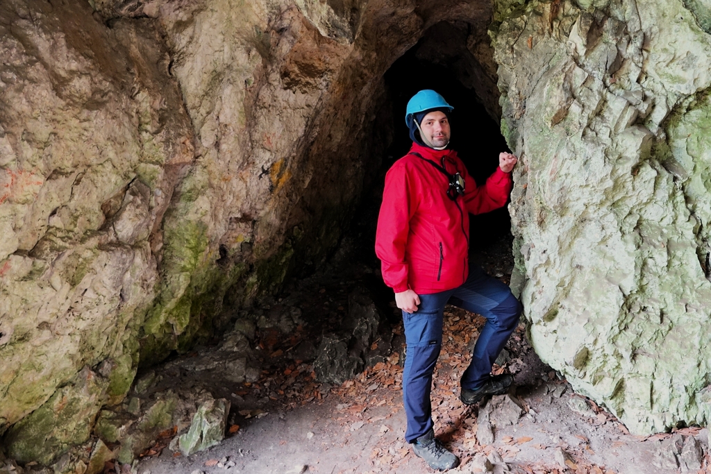 badacz u wejścia do jaskini