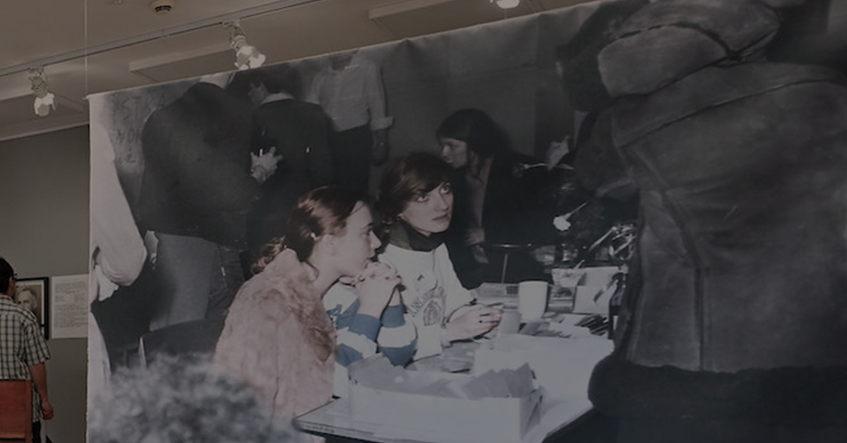 Na obrazku widać zdjęcie kobiet. Jest to fragment pracy artystycznej - wydruk zdjęcia na tkaninie wisi na żyłkach. Widoczne na nim są młode kobiety siedzące i rozmawiające ze sobą. Są to strajkujące studentki Uniwersytetu Łódzkiego. Strajk odbył się w 1981 roku.