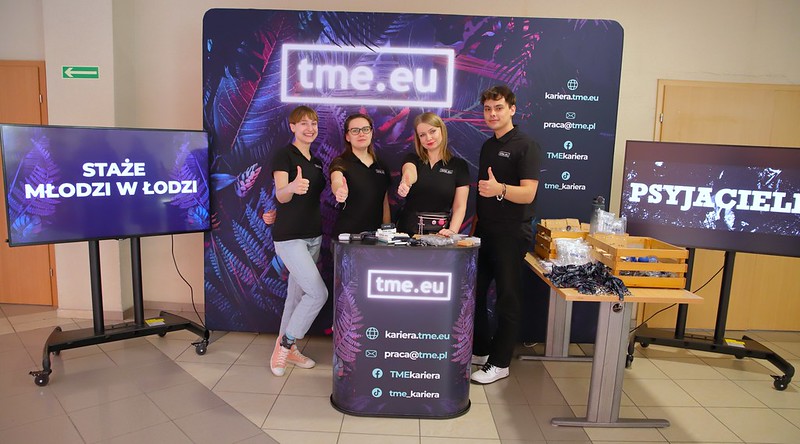 pracownicy TME na tle ścianki