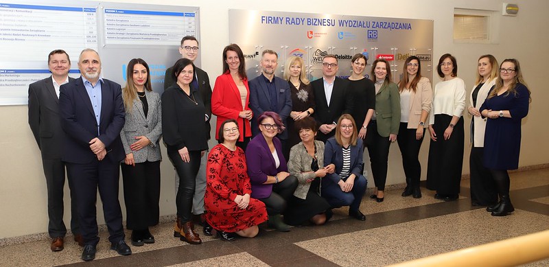 zdjęcie grupowe uczestników spotkania pod tablicą Rady Biznesu