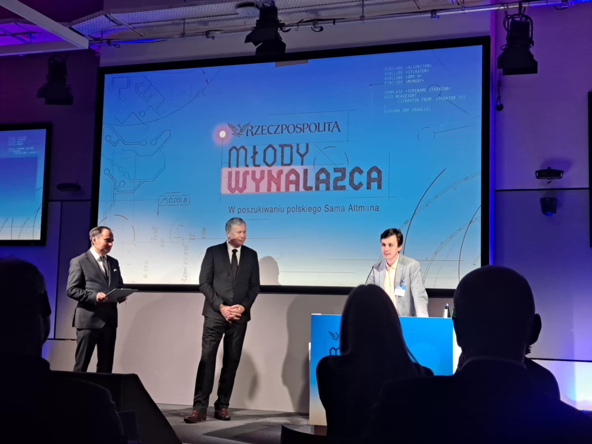 zdjęcie z wręczenia nagrody w kategorii "Młody wynalazca", na scenie od prawej: laureat Maciej Ślot oraz dwóch członków kapituły