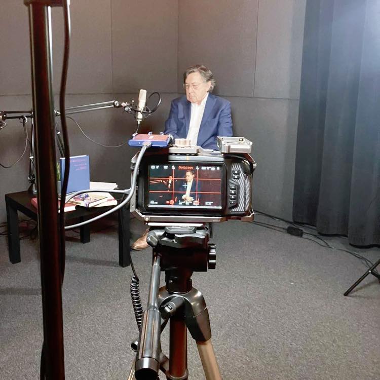 Kamera nagrywająca mężczyznę w marynarce.