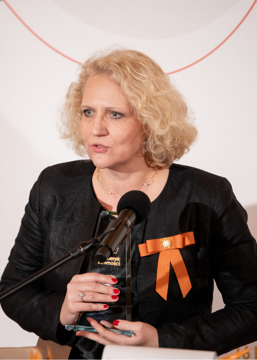 Blondwłosa kobieta trzymająca nagrodę-statuetkę