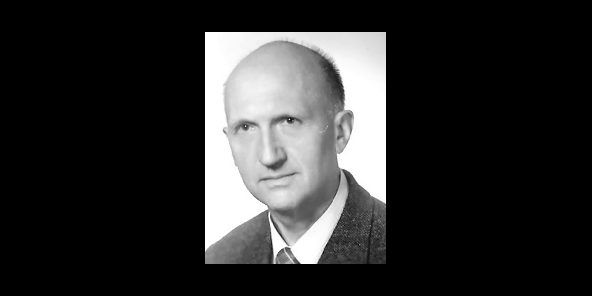 Czarno-białe zdjęcie łysego mężczyzny w garniturze.