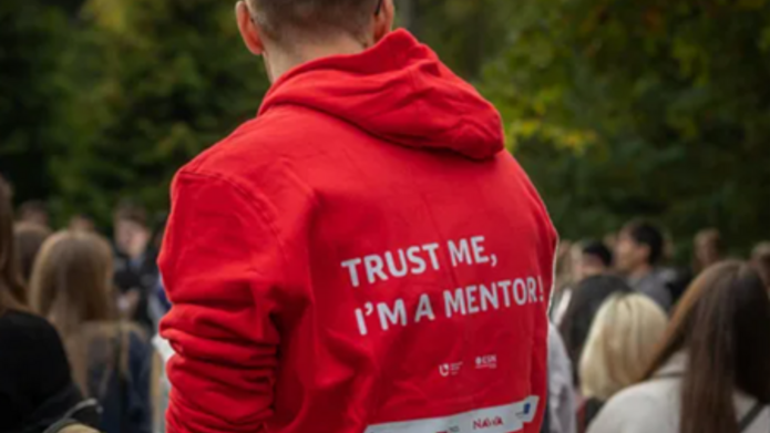 Zdjęcie studenta z czerwonej bluzie z napisem Trust me I'm a Mentor