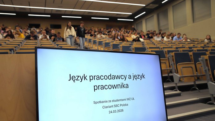 tytuł wykładu na ekranie monitora i widok na aulę