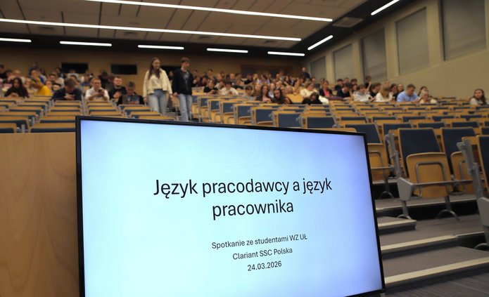 tytuł wykładu na ekranie monitora i widok na aulę