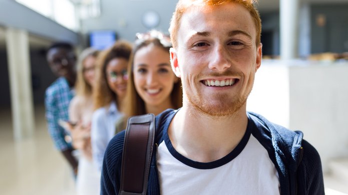 Grupa uśmiechniętych studentów stojących w rzędzie