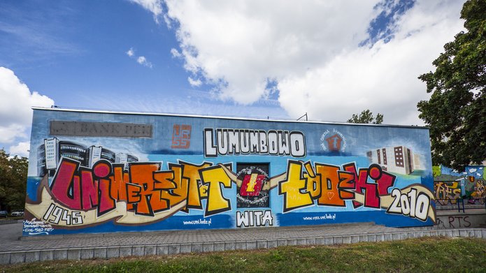 Kolorowe zdjęcie przedstawiające mural na budynku Centrum Obsługi Spraw Społecznych i Socjalnych Studentów i Doktorantów przy ulicy Patrice Lumumby 1; mural przedstawiaj napis: Lumumbowo, Uniwersytet Łódzki