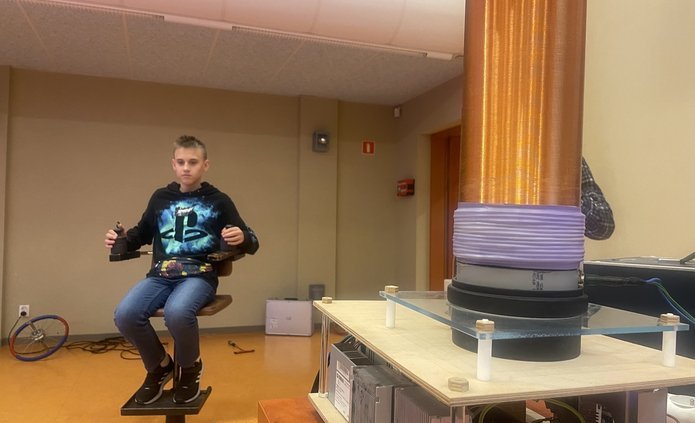 chłopak siedzący na krześle w tle przyrządy do wykonania eksperymentu