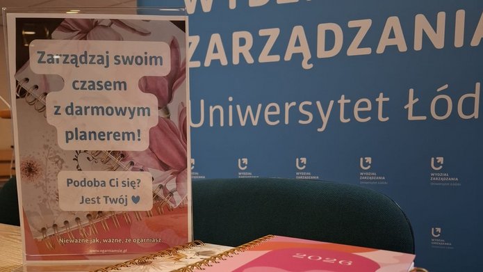 planery rozłożone na stole i kartka z informacją: Zarządzaj swoim czasem z bezpłatnym planerem. Podoba Ci się? Jest Twój.