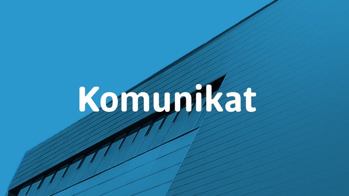 Napis Komunikat na tle budynku WZ