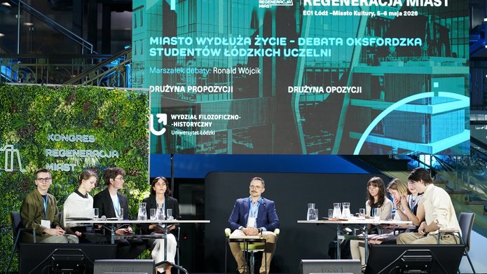 Widok na scenę z debatującymi drużynami w tle duży wyświetlacz konferencyjny