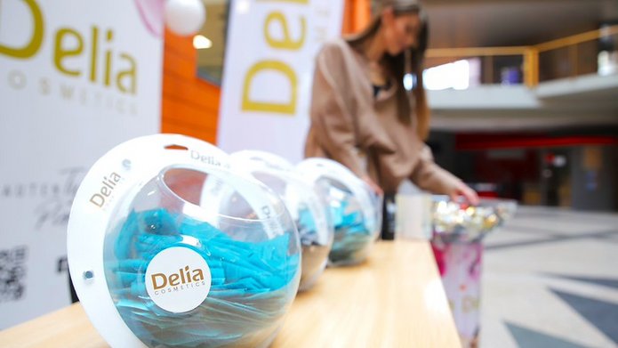 produkty Delii na tle roll-upa