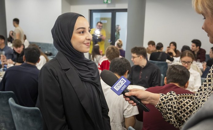 Zdjęcie przedstawia kobietę w hidżabie udzielającą wywiadu