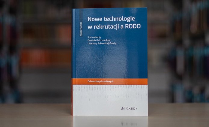 Książka na tle zbiorów bibliotecznych