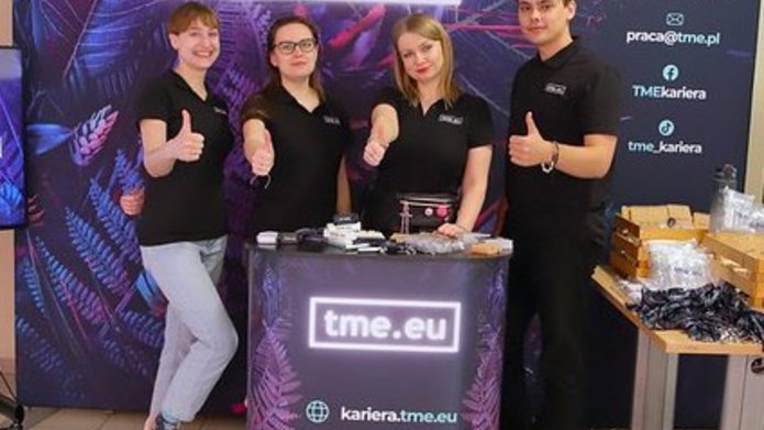 pracownicy TME na tle ścianki