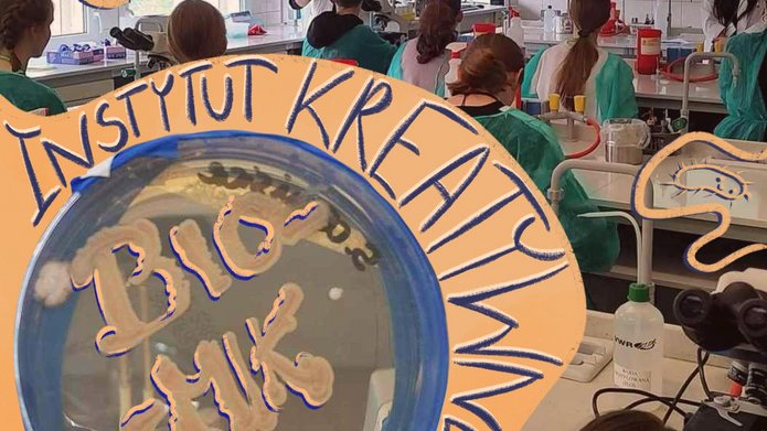 Grafika przedstawiająca szalkę Petriego z pożywką agarową i wzrostem mikroorganizmów, który tworzy słowa "Bio-Mik". W tle niewyraźna pracowania laboratoryjna i uczestnicy warsztatów, którzy siedzą przy stołach.
