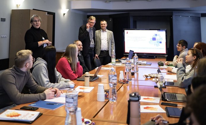 Osoby dyskutujące przy dużym stole