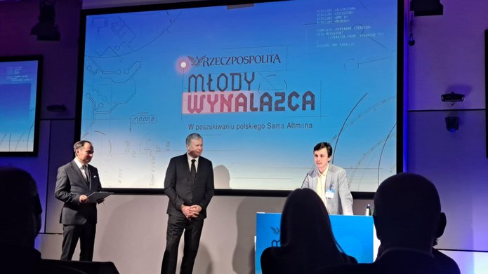 zdjęcie z wręczenia nagrody w kategorii "Młody wynalazca", na scenie od prawej: laureat Maciej Ślot oraz dwóch członków kapituły