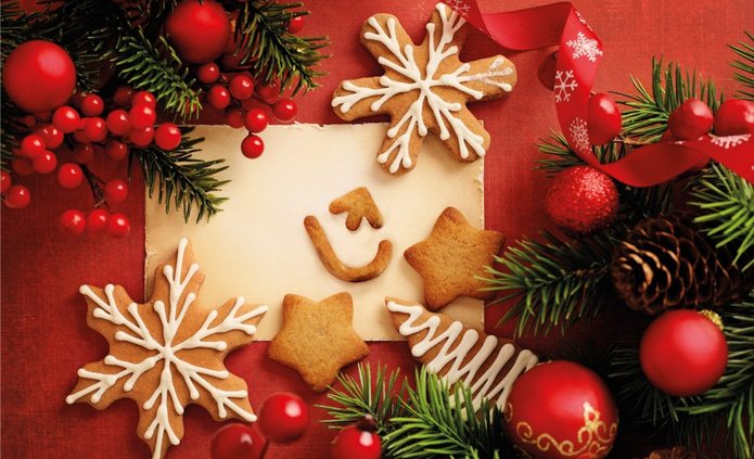 Karta świąteczna z czerwonymi bombkami i ciasteczkami w kształcie gwiazdek i logo UŁ