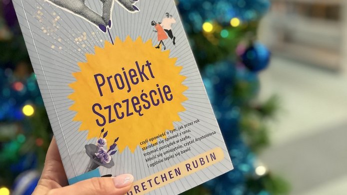 Okładka książki "Projekt Szczęście", w tle świątecznie przystrojona choinka.