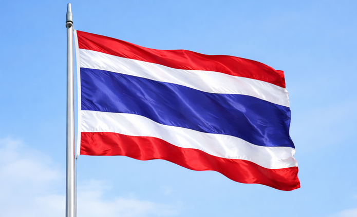 Powiewająca flaga Tajlandii na niebieskim tle