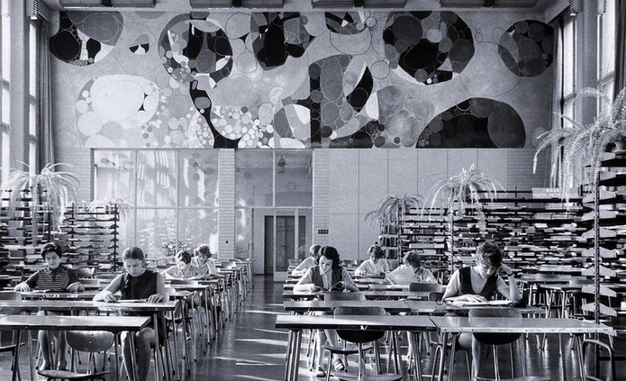 Czytelnia główna, zdjęcie archiwalne. Studenci uczą się przy stolikach.