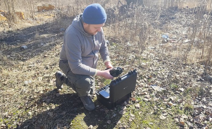 Członek zespołu (Maciej Adamiak) uruchamiający drona przed nalotem