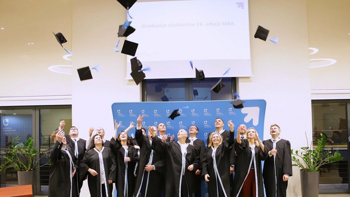 Grupa 26 edycji studiów MBA podczas wyrzutu biretów