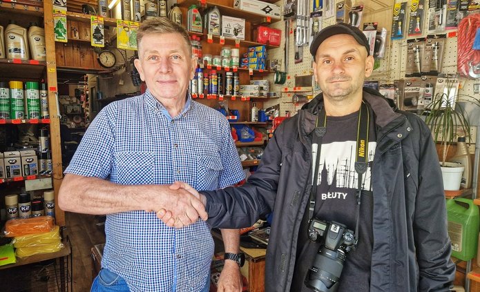 Na zdjęciu widać dwóch mężczyzn stojącyh w sklepie z artykułami motoryzacyjnymi.