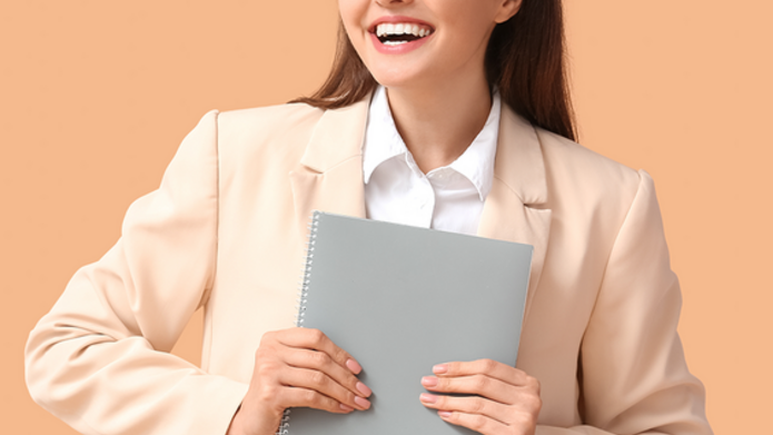 smiling student holding a notebook
