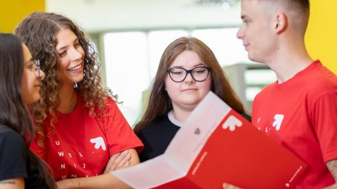4 studentów rozmawia na korytarzu