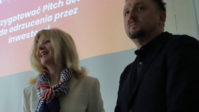 Prowadzący spotkanie na tle prezentacji