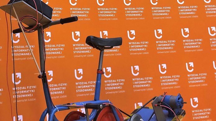 rower napędzany elektrycznie na tle pomarańczowej ścianki Wydziału