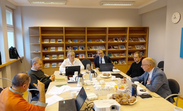 Grupa naukowców pracujących warsztatowo przy stole