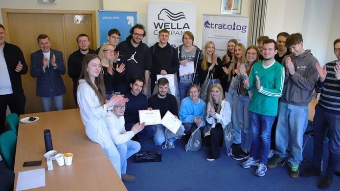 uczestnicy gry na tle roll-upów wydziału i sponsorów