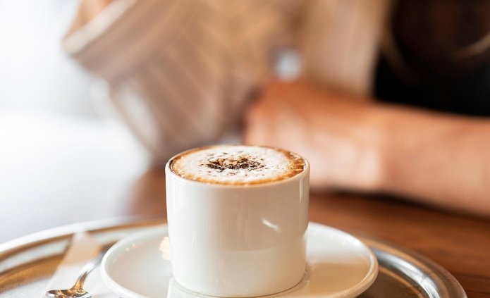 filiżanka z kawą soi na srebrnej tacy w le kobieta