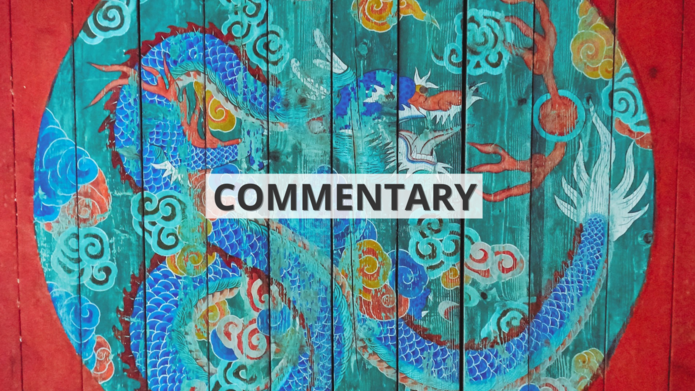 Namalowany na czerwonym drewnie wielobarwny okrąg ze smokiem we wschodnioazjatyckim stylu z napisem ‘commentary’ / A multicolored circle with a dragon painted on red wood in East Asian style with the inscription 'commentary'