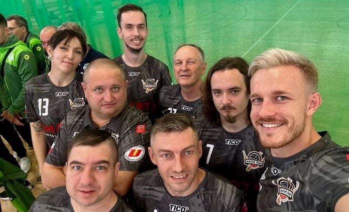 Zdjęcie ośmioosobowego zespołu sekcji siatkówki na siedząco razem z trenerem Piotrem Jaworowiczem