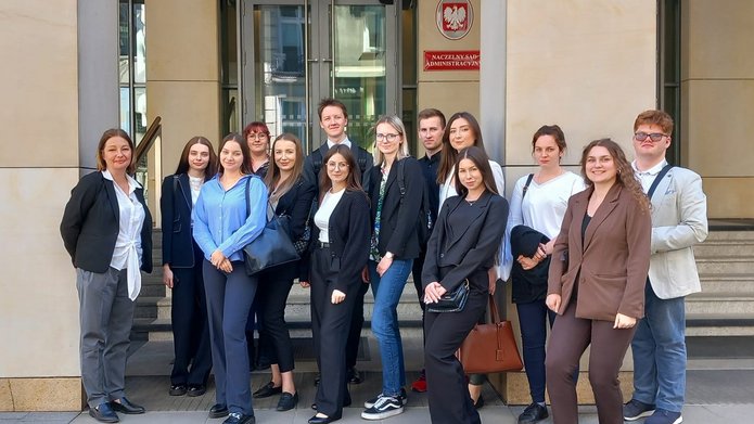 Grupa studentów ustawionych przed budynkiem sądu.