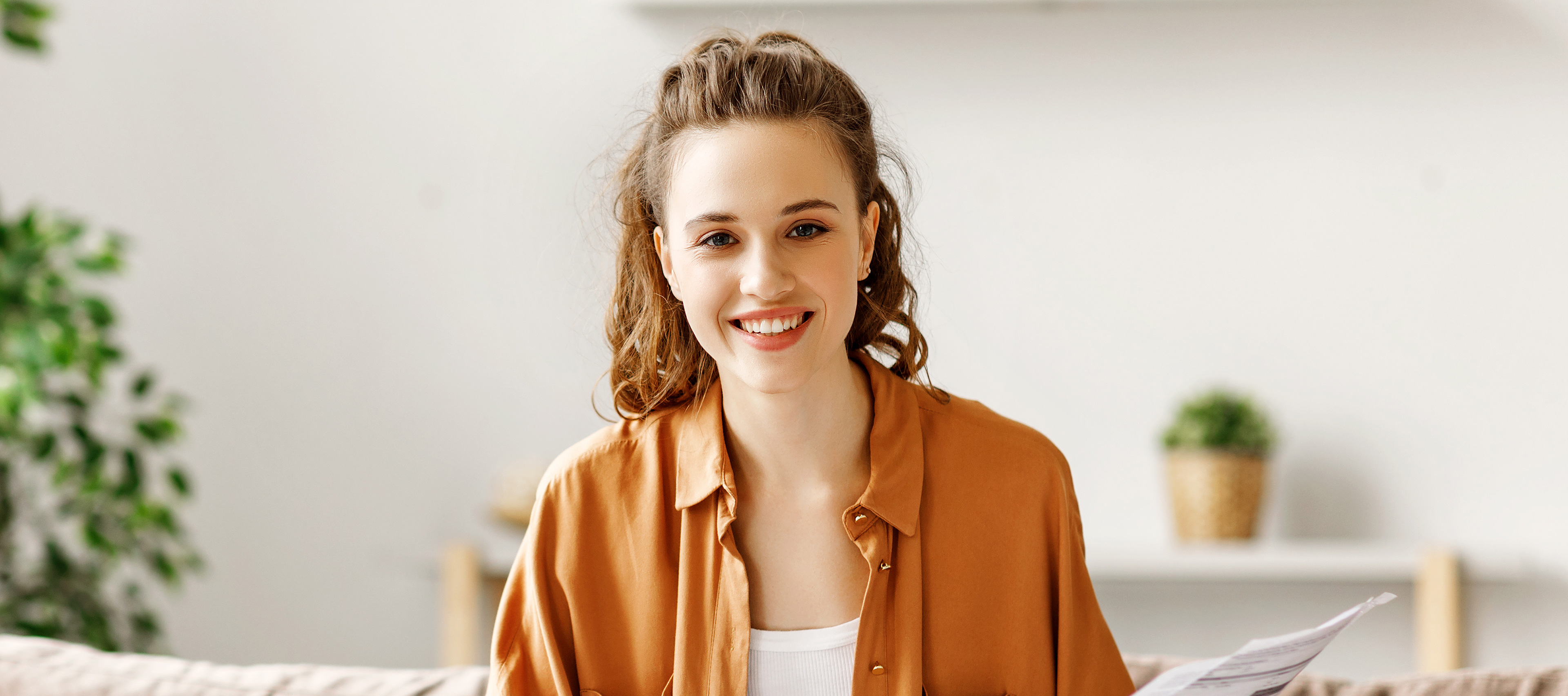 Uśmiechnięta dziewczyna w brązowej koszuli