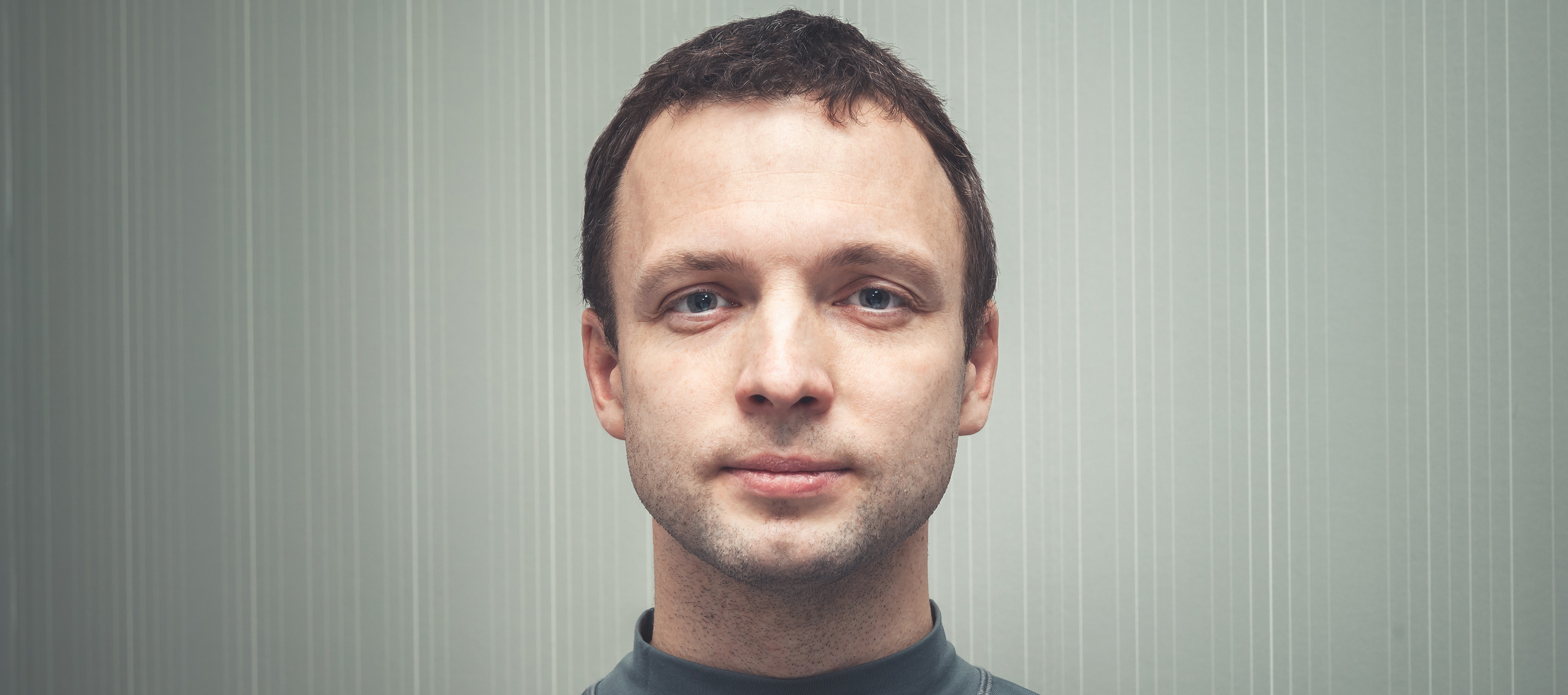 kolorowe zdjęcie młodego mężczyzny stojącego w neutralnym tle