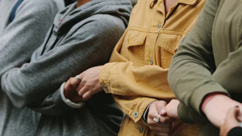 Sylwetki osób trzymających się za dłonie