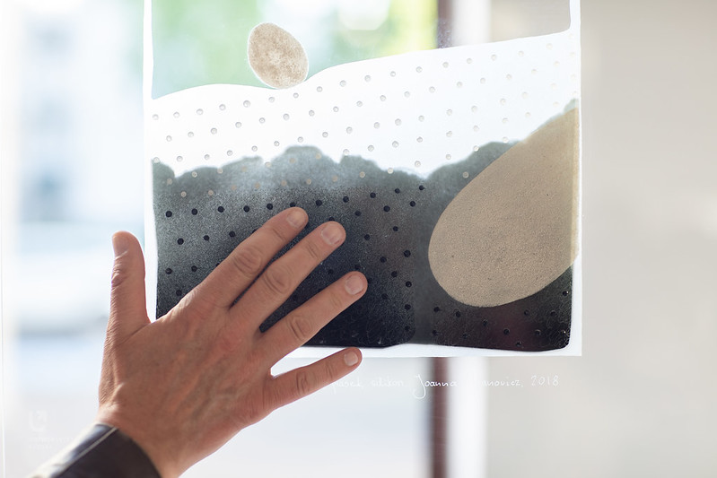 dłoń dotykająca pracy plastycznej na szkle